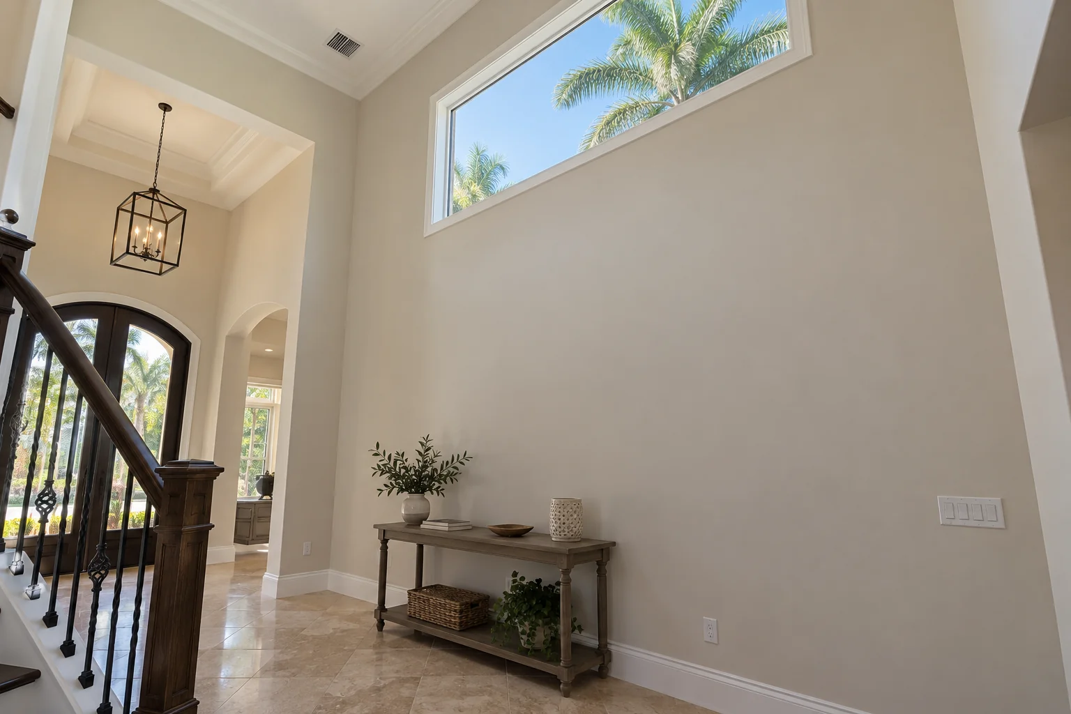 Smooth repaired foyer wall beneath a high window.