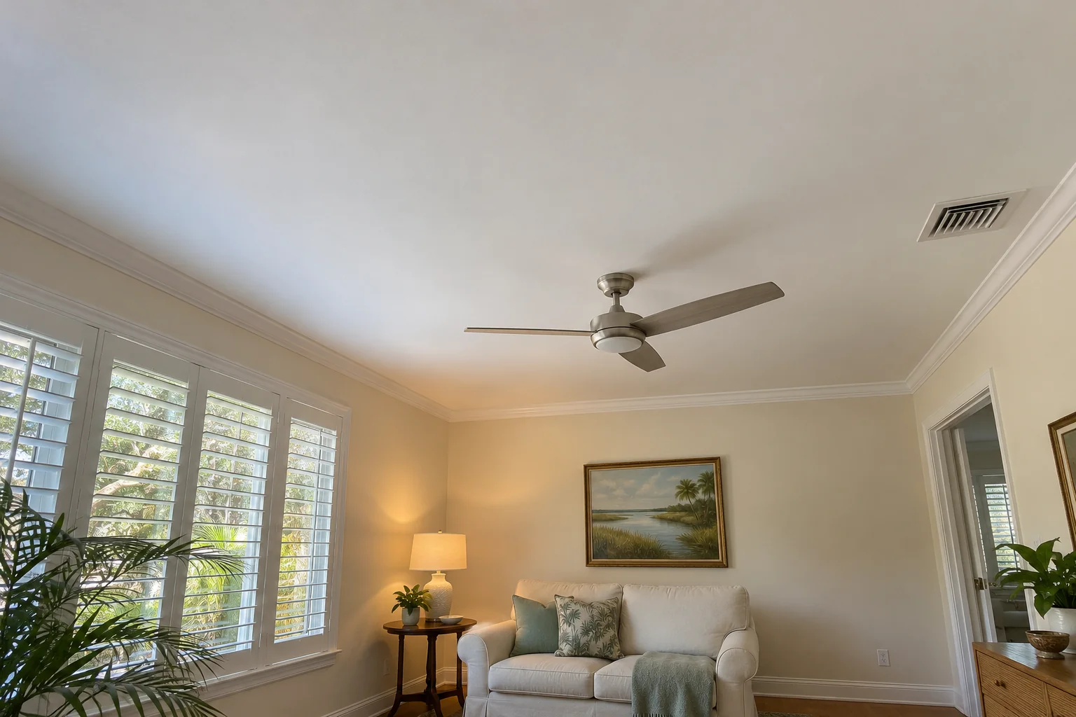 Small den with a smooth white ceiling and modern fan.