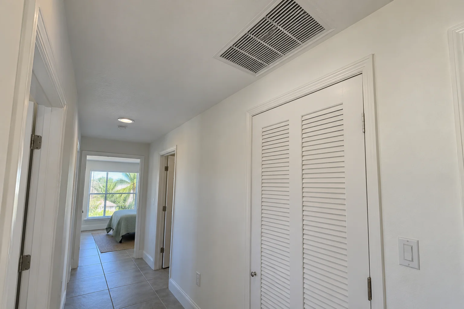 Repaired painted hall ceiling beside an air handler closet.
